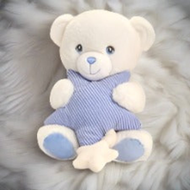 Plush teddy bear with blue outfit on a fluffy gray background