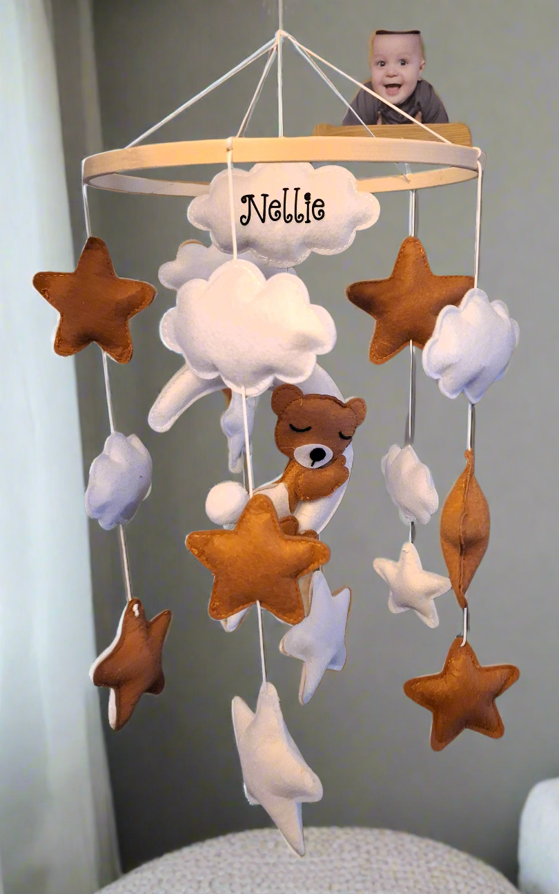 Hand-stitched felt stars and clouds hanging from baby mobile – caramel and white palette